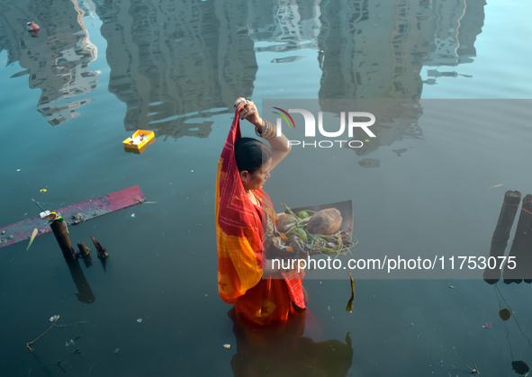 A Hindu woman worships the Sun god in the early morning during the religious festival of Chhath Puja at a pond in Kolkata, India, on Novembe...