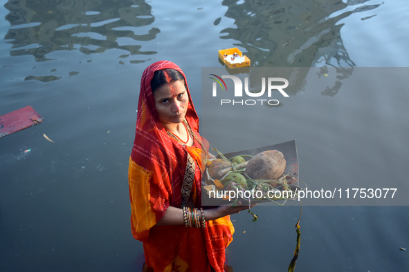 A Hindu woman worships the Sun god in the early morning during the religious festival of Chhath Puja at a pond in Kolkata, India, on Novembe...