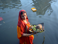 A Hindu woman worships the Sun god in the early morning during the religious festival of Chhath Puja at a pond in Kolkata, India, on Novembe...