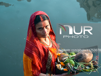 A Hindu woman worships the Sun god in the early morning during the religious festival of Chhath Puja at a pond in Kolkata, India, on Novembe...