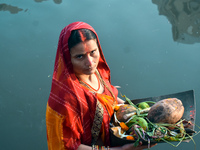 A Hindu woman worships the Sun god in the early morning during the religious festival of Chhath Puja at a pond in Kolkata, India, on Novembe...