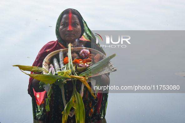 A Hindu woman worships the Sun god in the early morning during the religious festival of Chhath Puja at a pond in Kolkata, India, on Novembe...