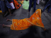 A Hindu devotee lies on the road as she worships the Sun god at dawn on the banks of the river Ganges during the last day of the Hindu relig...