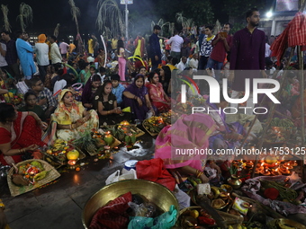 Hindu devotees hold offerings at dawn as they offer prayers to the Sun god on the banks of the river Ganges during the last day of the Hindu...