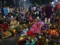 Hindu devotees hold offerings at dawn as they offer prayers to the Sun god on the banks of the river Ganges during the last day of the Hindu...