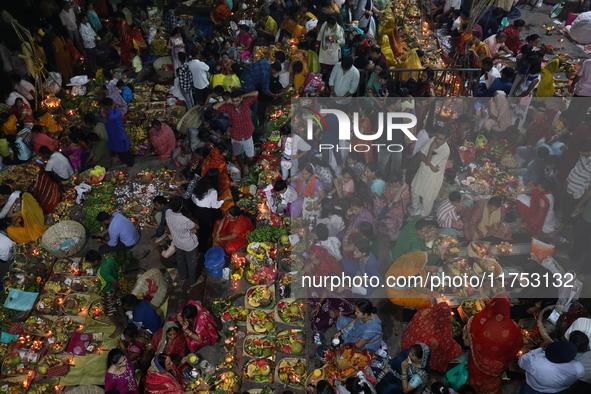 Hindu devotees hold offerings at dawn as they offer prayers to the Sun god on the banks of the river Ganges during the last day of the Hindu...