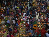 Hindu devotees hold offerings at dawn as they offer prayers to the Sun god on the banks of the river Ganges during the last day of the Hindu...