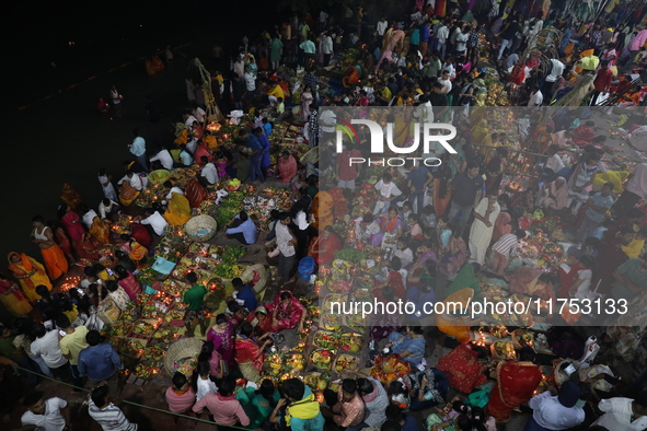 Hindu devotees hold offerings at dawn as they offer prayers to the Sun god on the banks of the river Ganges during the last day of the Hindu...