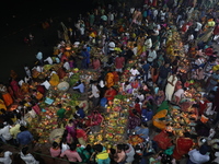 Hindu devotees hold offerings at dawn as they offer prayers to the Sun god on the banks of the river Ganges during the last day of the Hindu...