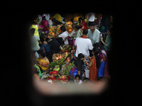 Hindu devotees hold offerings at dawn as they offer prayers to the Sun god on the banks of the river Ganges during the last day of the Hindu...