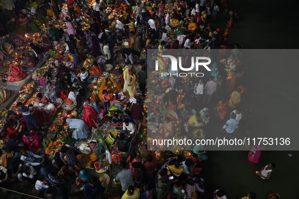 Hindu devotees hold offerings at dawn as they offer prayers to the Sun god on the banks of the river Ganges during the last day of the Hindu...