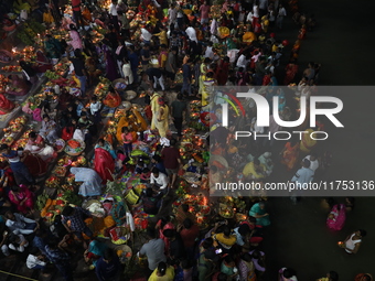 Hindu devotees hold offerings at dawn as they offer prayers to the Sun god on the banks of the river Ganges during the last day of the Hindu...