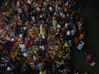 Hindu devotees hold offerings at dawn as they offer prayers to the Sun god on the banks of the river Ganges during the last day of the Hindu...