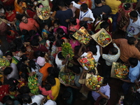 Hindu devotees hold offerings at dawn as they offer prayers to the Sun god on the banks of the river Ganges during the last day of the Hindu...