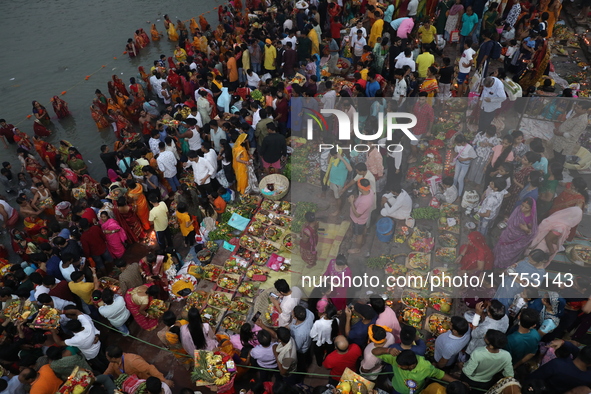 Hindu devotees hold offerings during the early morning as they offer prayers to the Sun god on the banks of the river Ganges during the last...