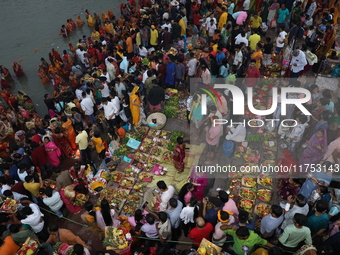 Hindu devotees hold offerings during the early morning as they offer prayers to the Sun god on the banks of the river Ganges during the last...