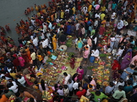 Hindu devotees hold offerings during the early morning as they offer prayers to the Sun god on the banks of the river Ganges during the last...