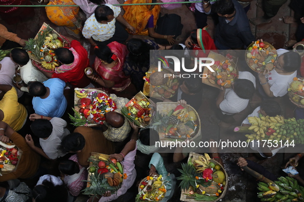 Hindu devotees hold offerings at dawn as they offer prayers to the Sun god on the banks of the river Ganges during the last day of the Hindu...