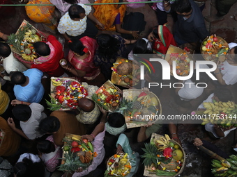 Hindu devotees hold offerings at dawn as they offer prayers to the Sun god on the banks of the river Ganges during the last day of the Hindu...