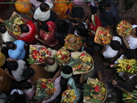 Hindu devotees hold offerings at dawn as they offer prayers to the Sun god on the banks of the river Ganges during the last day of the Hindu...