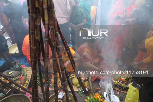 Hindu devotees hold offerings during the early morning as they offer prayers to the Sun god on the banks of the river Ganges during the last...