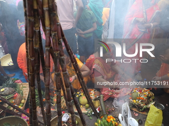 Hindu devotees hold offerings during the early morning as they offer prayers to the Sun god on the banks of the river Ganges during the last...