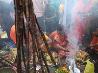 Hindu devotees hold offerings during the early morning as they offer prayers to the Sun god on the banks of the river Ganges during the last...