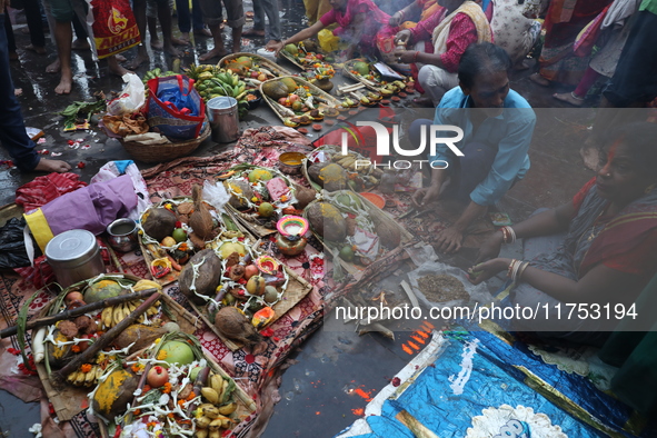 Hindu devotees hold offerings during the early morning as they offer prayers to the Sun god on the banks of the river Ganges during the last...