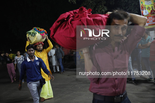 Hindu devotees carry offerings to worship the Sun god at dawn on the banks of the river Ganges during the last day of the Hindu religious fe...