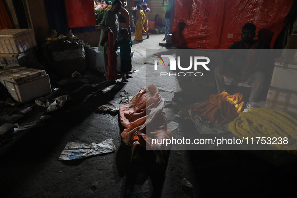 A Hindu devotee lies on the road as she worships the Sun god at dawn on the banks of the river Ganges during the last day of the Hindu relig...