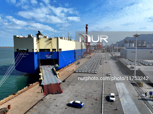 A roll-on wheel is loaded with cars for export at the terminal of Orient Port Branch in Lianyungang Port in Lianyungang, China, on November...