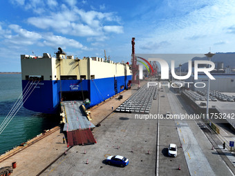 A roll-on wheel is loaded with cars for export at the terminal of Orient Port Branch in Lianyungang Port in Lianyungang, China, on November...