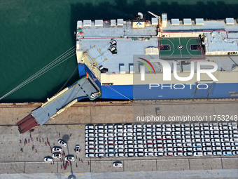 A roll-on wheel is loaded with cars for export at the terminal of Orient Port Branch in Lianyungang Port in Lianyungang, China, on November...