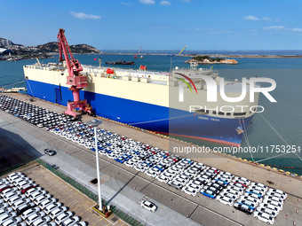 A roll-on wheel is loaded with cars for export at the terminal of Orient Port Branch in Lianyungang Port in Lianyungang, China, on November...