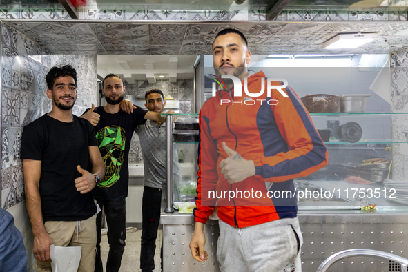 Young men pose to be photographed in a small restaurant in Tunis, central Tunisia on November 2, 2024. Tunisia is well known for its natural...