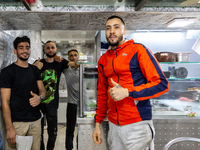 Young men pose to be photographed in a small restaurant in Tunis, central Tunisia on November 2, 2024. Tunisia is well known for its natural...