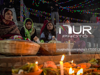 A Hindu devotee lights traditional oil lamps as she offers prayers to the sun during the Chhath Puja festival on the banks of the Bagmati Ri...