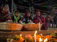 A Hindu devotee lights traditional oil lamps as she offers prayers to the sun during the Chhath Puja festival on the banks of the Bagmati Ri...