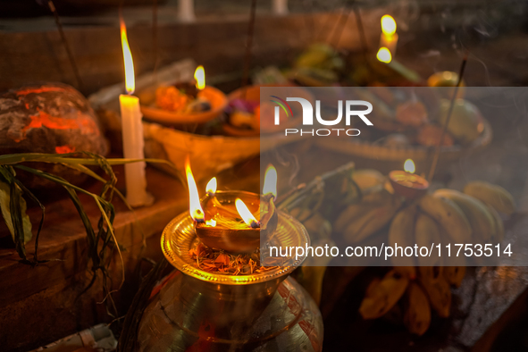 A Hindu devotee lights traditional oil lamps as she offers prayers to the sun during the Chhath Puja festival on the banks of the Bagmati Ri...