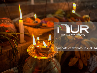 A Hindu devotee lights traditional oil lamps as she offers prayers to the sun during the Chhath Puja festival on the banks of the Bagmati Ri...