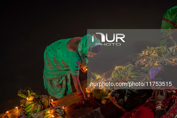 A Hindu devotee lights traditional oil lamps as she offers prayers to the sun during the Chhath Puja festival on the banks of the Bagmati Ri...