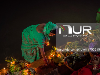 A Hindu devotee lights traditional oil lamps as she offers prayers to the sun during the Chhath Puja festival on the banks of the Bagmati Ri...