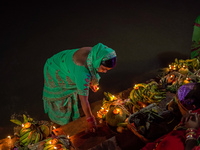 A Hindu devotee lights traditional oil lamps as she offers prayers to the sun during the Chhath Puja festival on the banks of the Bagmati Ri...