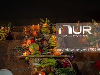 A Hindu devotee lights traditional oil lamps as she offers prayers to the sun during the Chhath Puja festival on the banks of the Bagmati Ri...