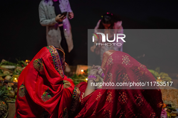 A Hindu devotee lights traditional oil lamps as she offers prayers to the sun during the Chhath Puja festival on the banks of the Bagmati Ri...