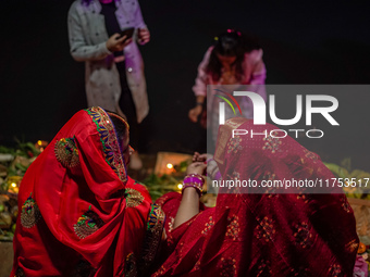 A Hindu devotee lights traditional oil lamps as she offers prayers to the sun during the Chhath Puja festival on the banks of the Bagmati Ri...