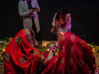 A Hindu devotee lights traditional oil lamps as she offers prayers to the sun during the Chhath Puja festival on the banks of the Bagmati Ri...