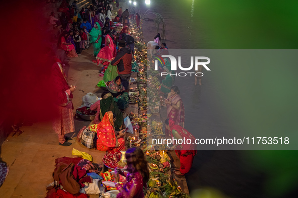 A Hindu devotee lights traditional oil lamps as she offers prayers to the sun during the Chhath Puja festival on the banks of the Bagmati Ri...