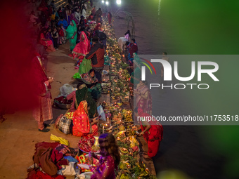 A Hindu devotee lights traditional oil lamps as she offers prayers to the sun during the Chhath Puja festival on the banks of the Bagmati Ri...