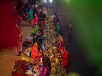 A Hindu devotee lights traditional oil lamps as she offers prayers to the sun during the Chhath Puja festival on the banks of the Bagmati Ri...